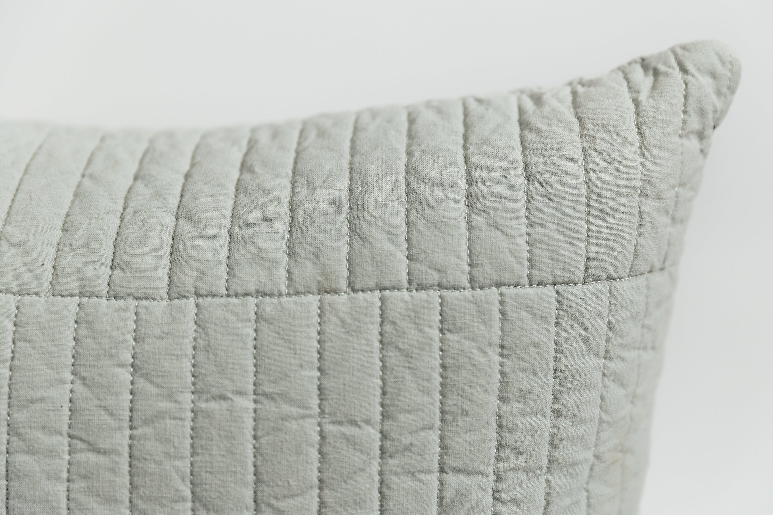 A close up on the piano tile stitching detail on a blue pillow cover.