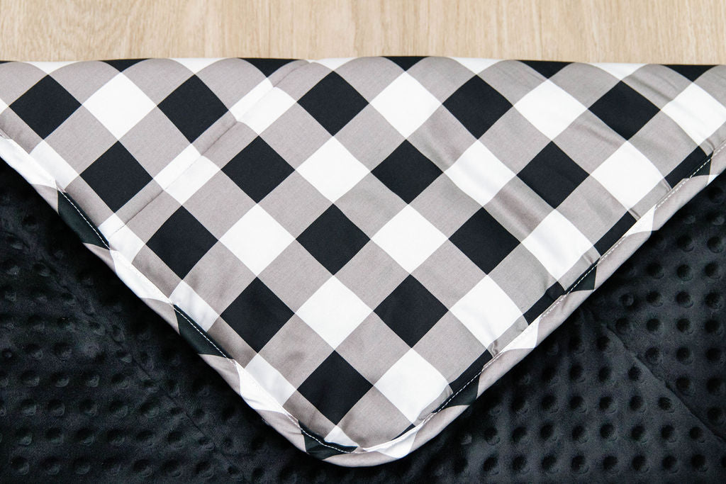 corner of white, black and gray child's blanket