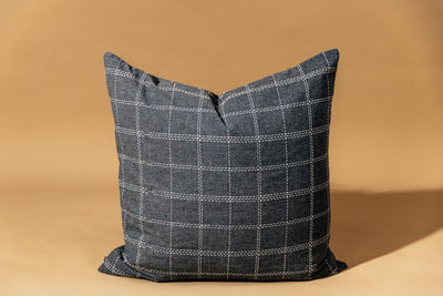 A grid pattern gray euro sham sitting on a brown backdrop.