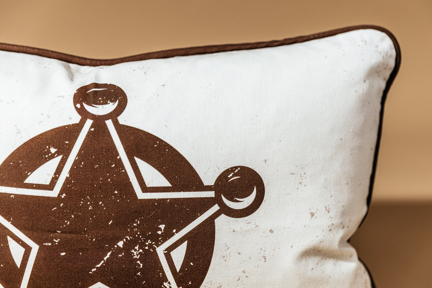 A close up of the star print on a western pillow arranged on a brown backdrop.