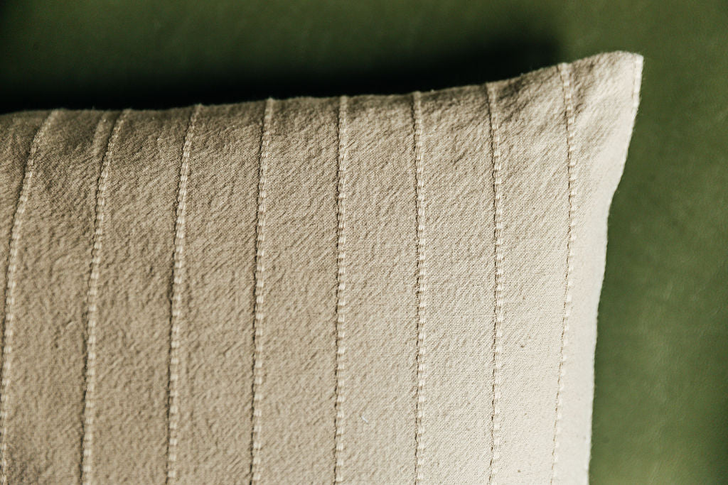 A close up of a neutral striped euro sham to highlight the vertical stitching detail