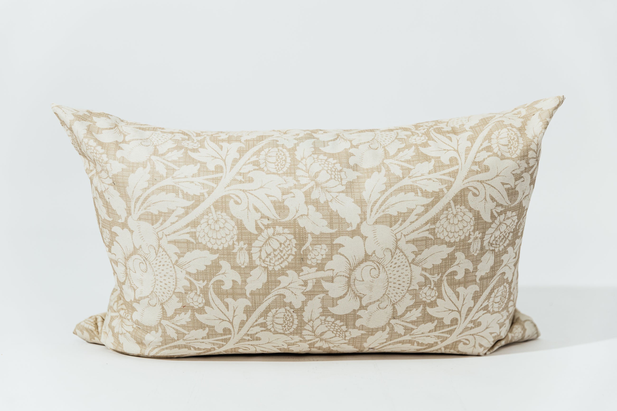 A floral lumbar pillow on a white backdrop.