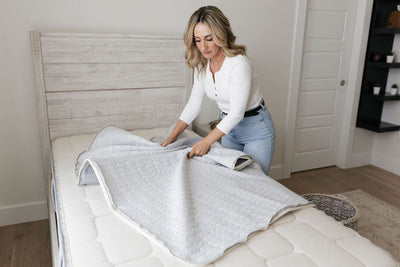 A mother removing the unzippable top layer of her machine washable zipper mattress.