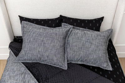 Dark charcoal zipper bedding unzipped diagonally showing black minky and patterned interior