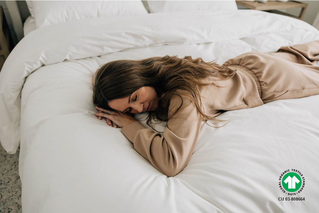 woman laying across bed  on top of organic duvet