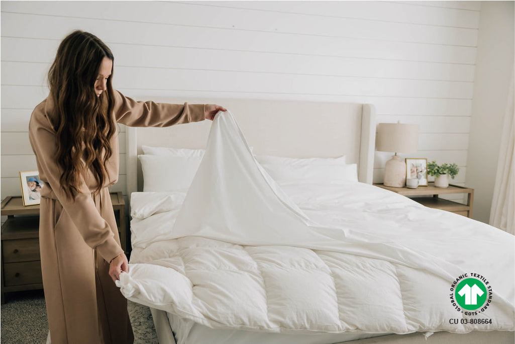 Woman putting on an organic duvet cover on a duvet insert