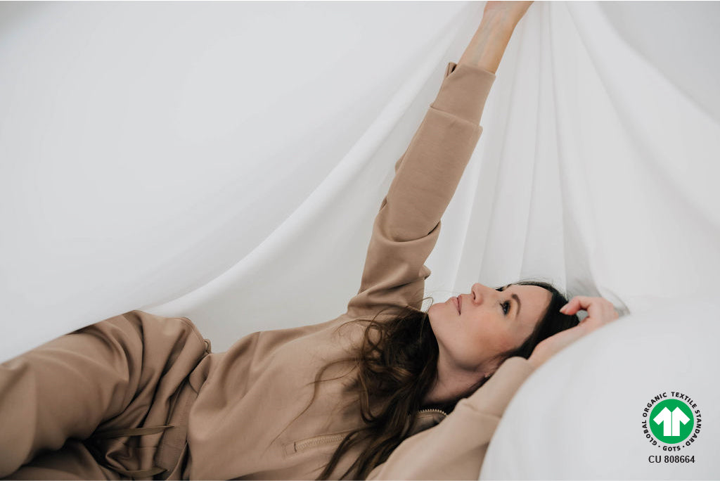 woman playing underneath organic zipper sheets