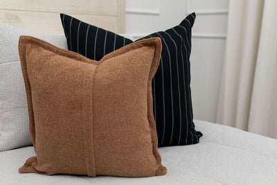 Brown plush pillow with black and white striped euro on gray zipper bedding