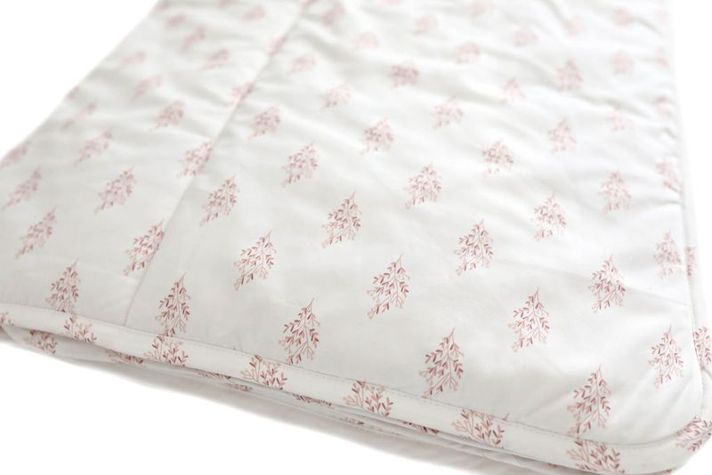 white blanket with pink floral pattern