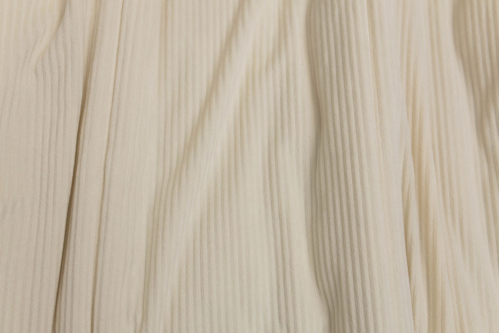 A close up view of a cream minky striped blanket.