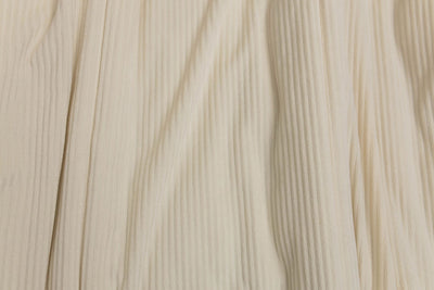 A close up view of a cream minky striped blanket.