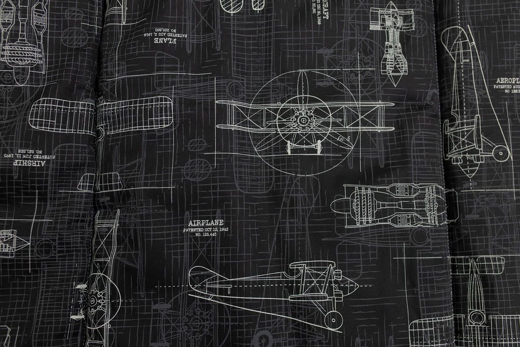 An airplane design charcoal gray print blanket close up view.