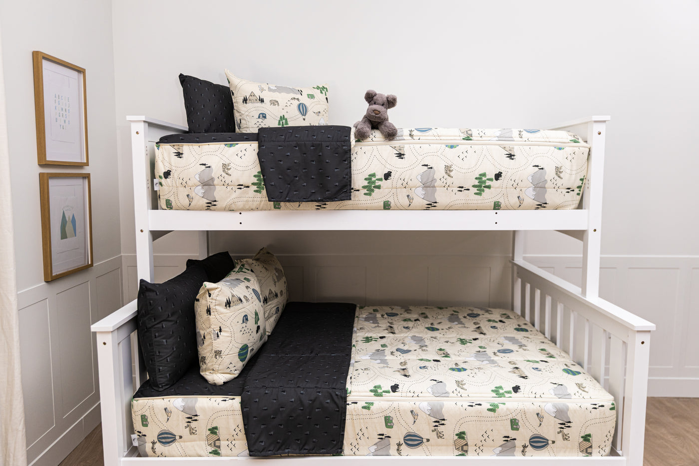 A bunk bed where both bunks are made with outdoor themed zipper bedding, the top bunk a twin bed and the bottom bunk a full bed.