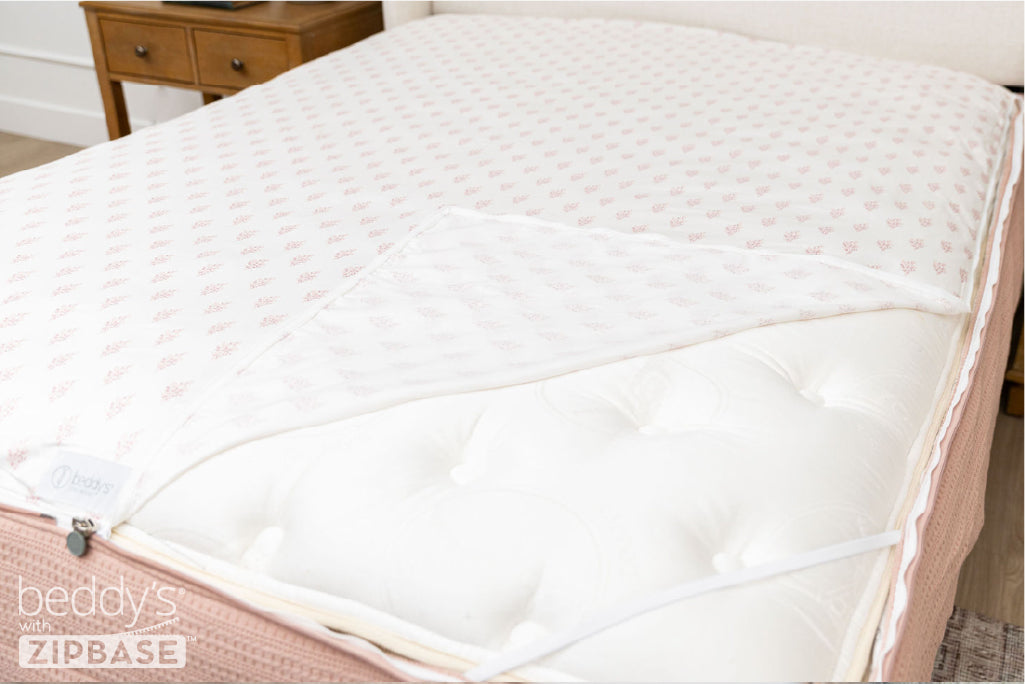 A ZipBase sheet partially unzipped and pulled back to show how it detaches from the rest of the base sheet wrapped around the sides of the mattress.