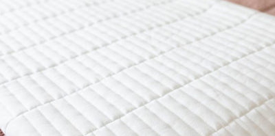 Close up on the piano key stitching of a white throw blanket