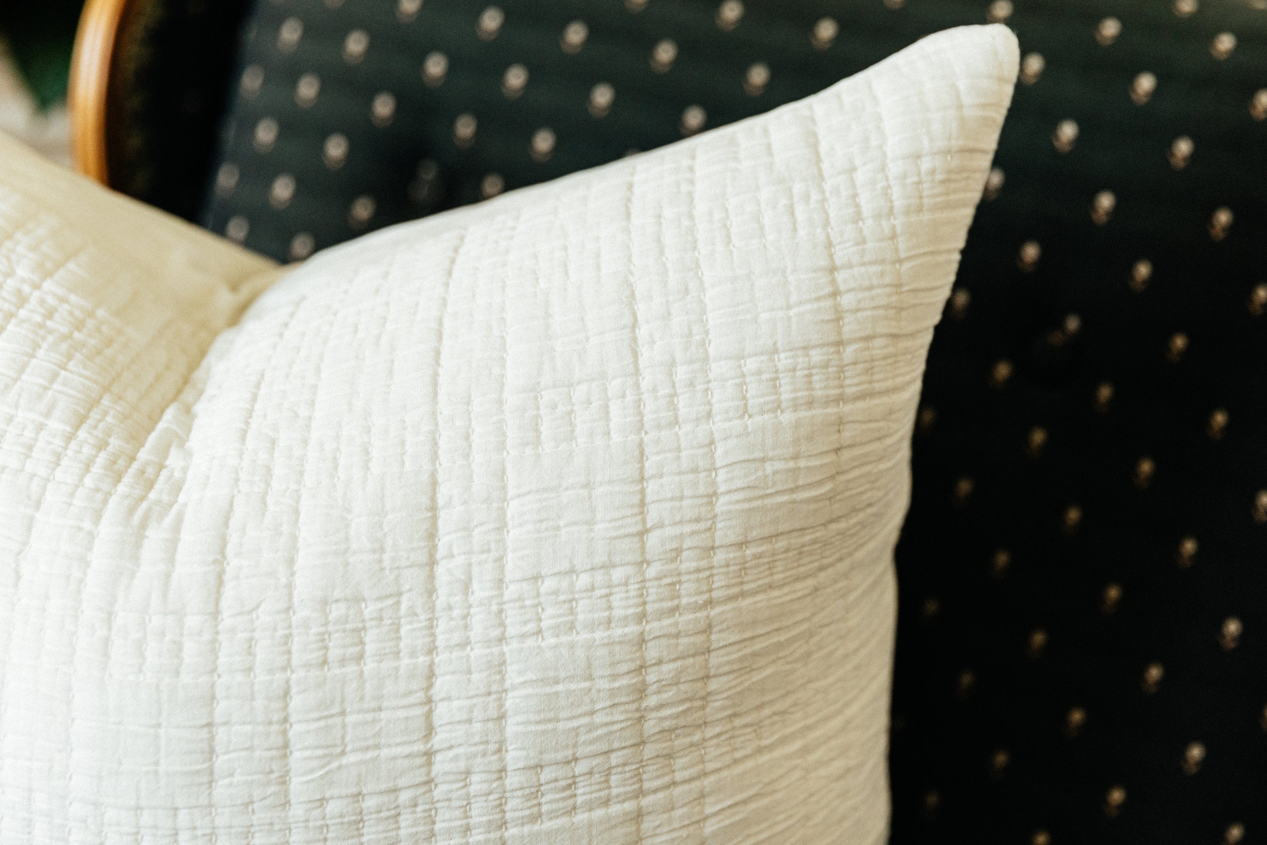 Corner shot of white textured cotton pillow on chair