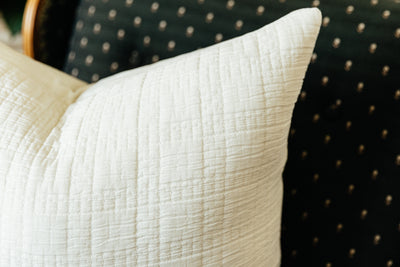 Corner shot of white textured cotton pillow on chair