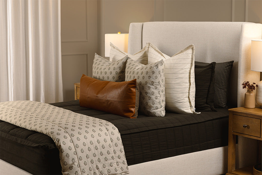 Knitted, black zipper bedding with white, floral, and leather accessories. 