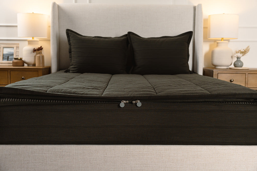 End of bed showing double zippers on black knit zipper bedding.
