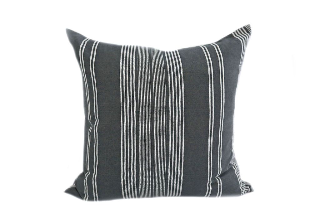 A dark gray and white striped pillow on a white background.