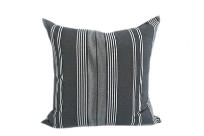 A dark gray and white striped pillow on a white background.