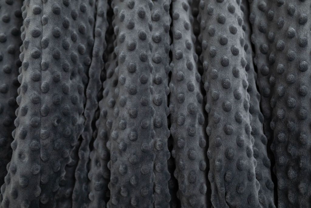 A close up of a softly textured charcoal gray minky blanket.