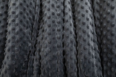 A close up of a softly textured charcoal gray minky blanket.