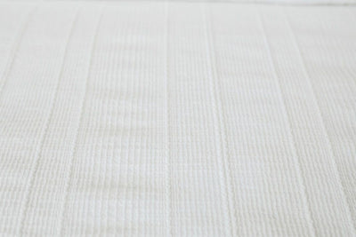 A close up view of the textured woven detailing on a white zipper duvet.
