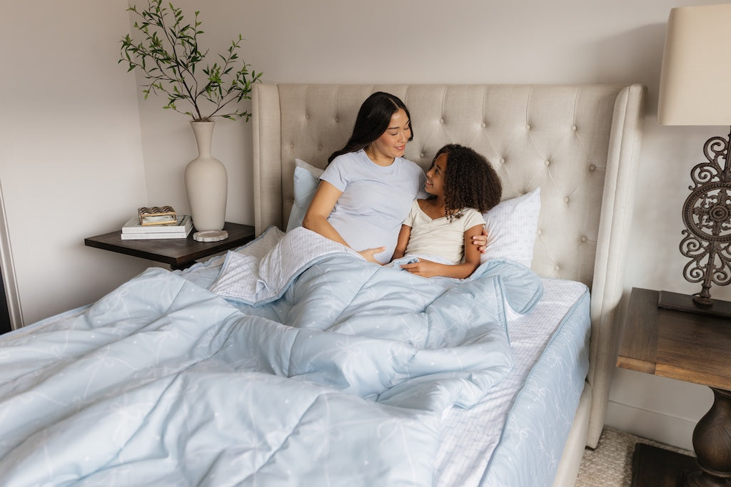 Mother and daughter snuggled in queen size zipper bedding with bows design.