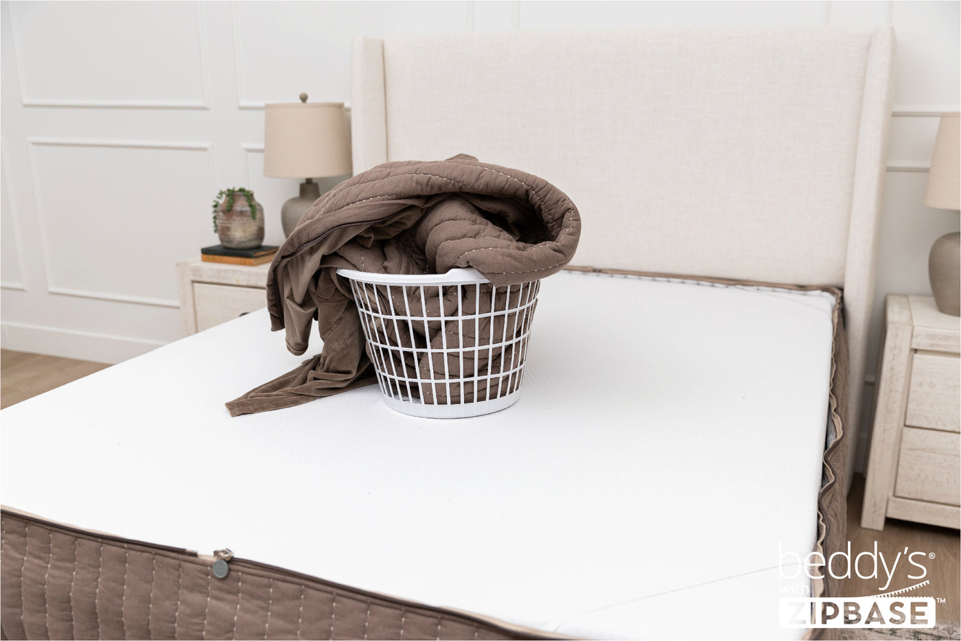 the ZipBase sheet and top comforter of a Beddy's set sitting in a basket on top of a mattress
