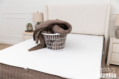 the ZipBase sheet and top comforter of a Beddy's set sitting in a basket on top of a mattress
