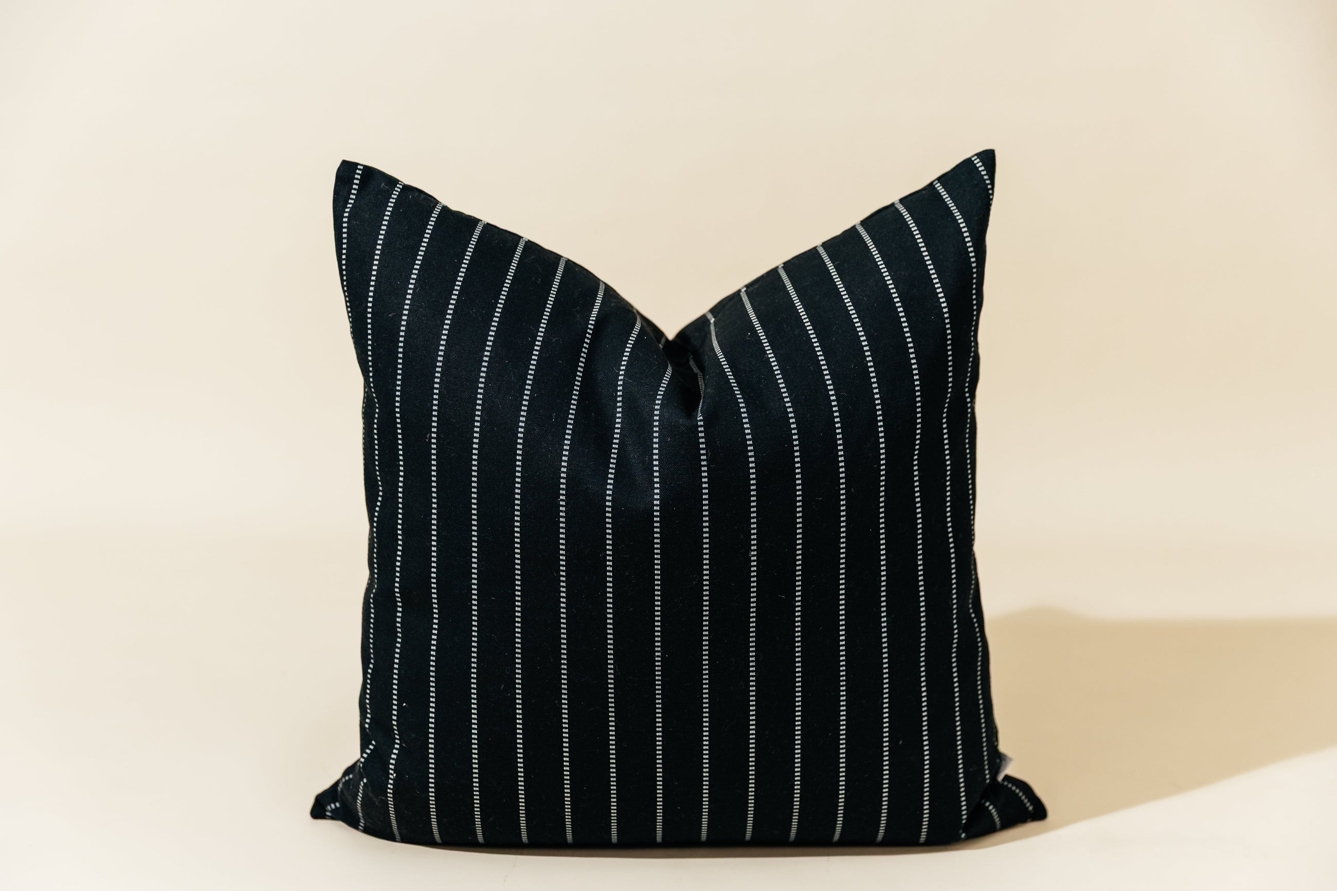 A black striped euro pillow arranged on a cream background.