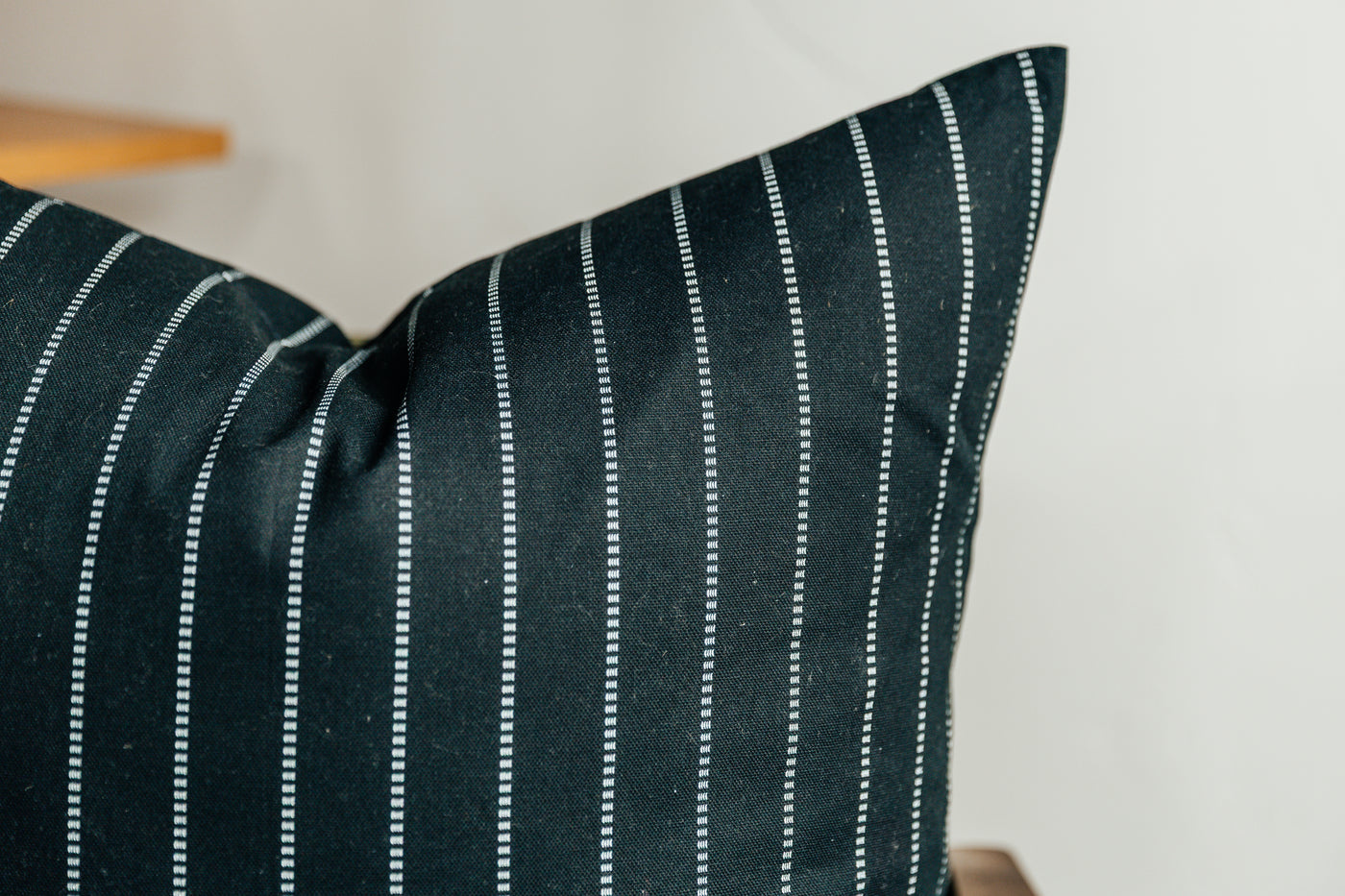 A close up corner view of a black striped euro pillow.
