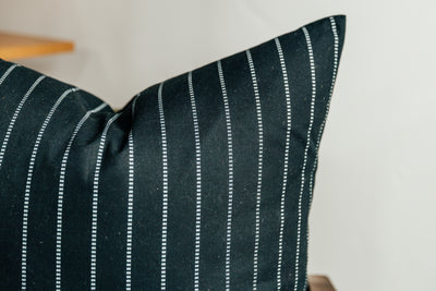 A close up corner view of a black striped euro pillow.