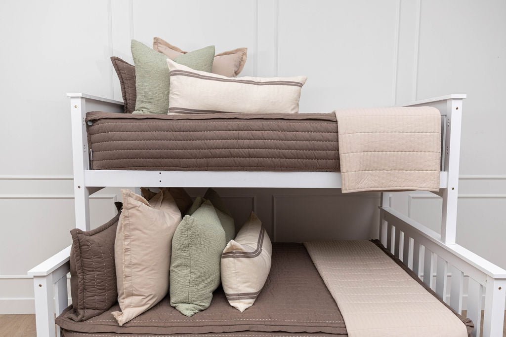 A bunk bed where both bunks are made with brown zipper bedding and neutral and sage bedding accessories