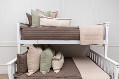 A bunk bed where both bunks are made with brown zipper bedding and neutral and sage bedding accessories