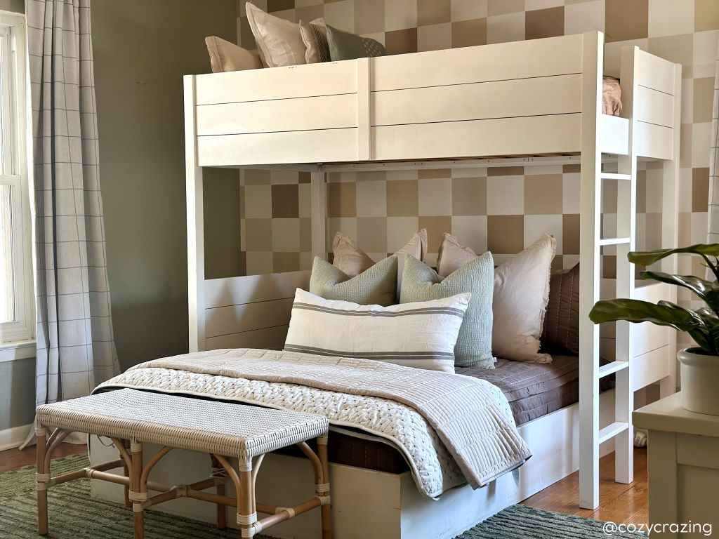 A bunk bed where both beds are made with zipper bedding and an assortment of neutral bedding accessories