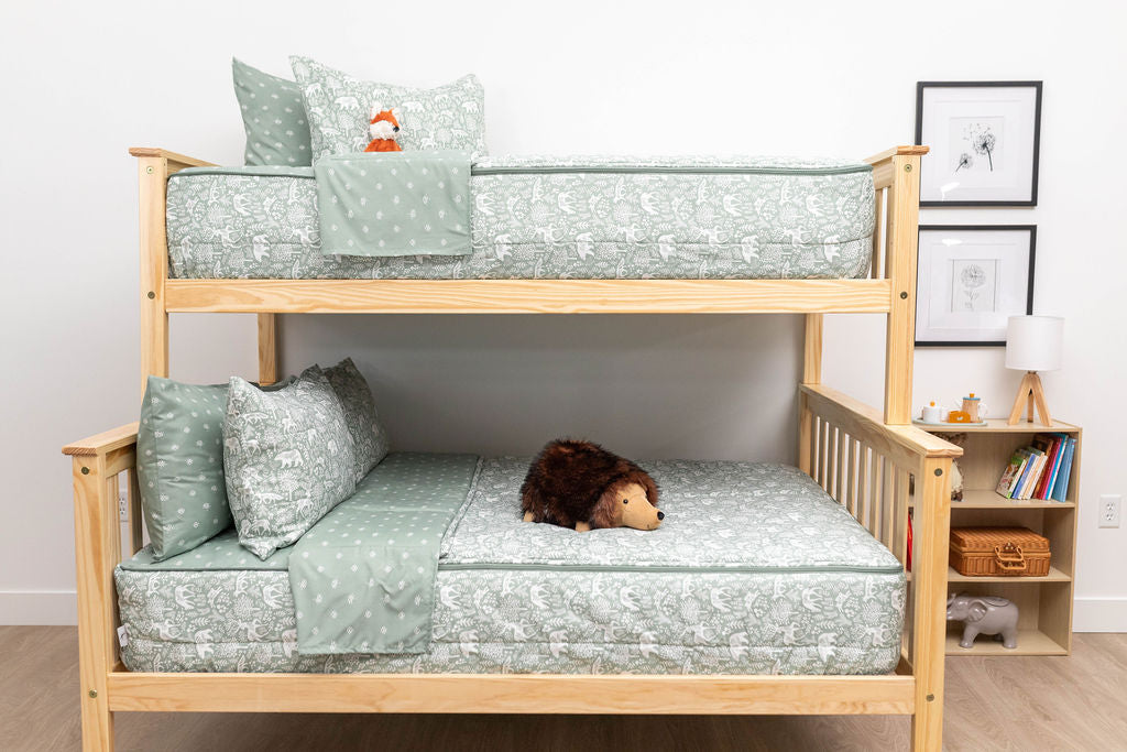 A bunk bed where both bunks are made with sage green forest animal kids zipper bedding
