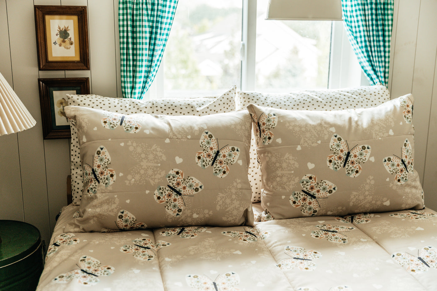 A full size bed made with butterfly zipper bedding, the pillows propped up to showcase the pillowcases and shams.