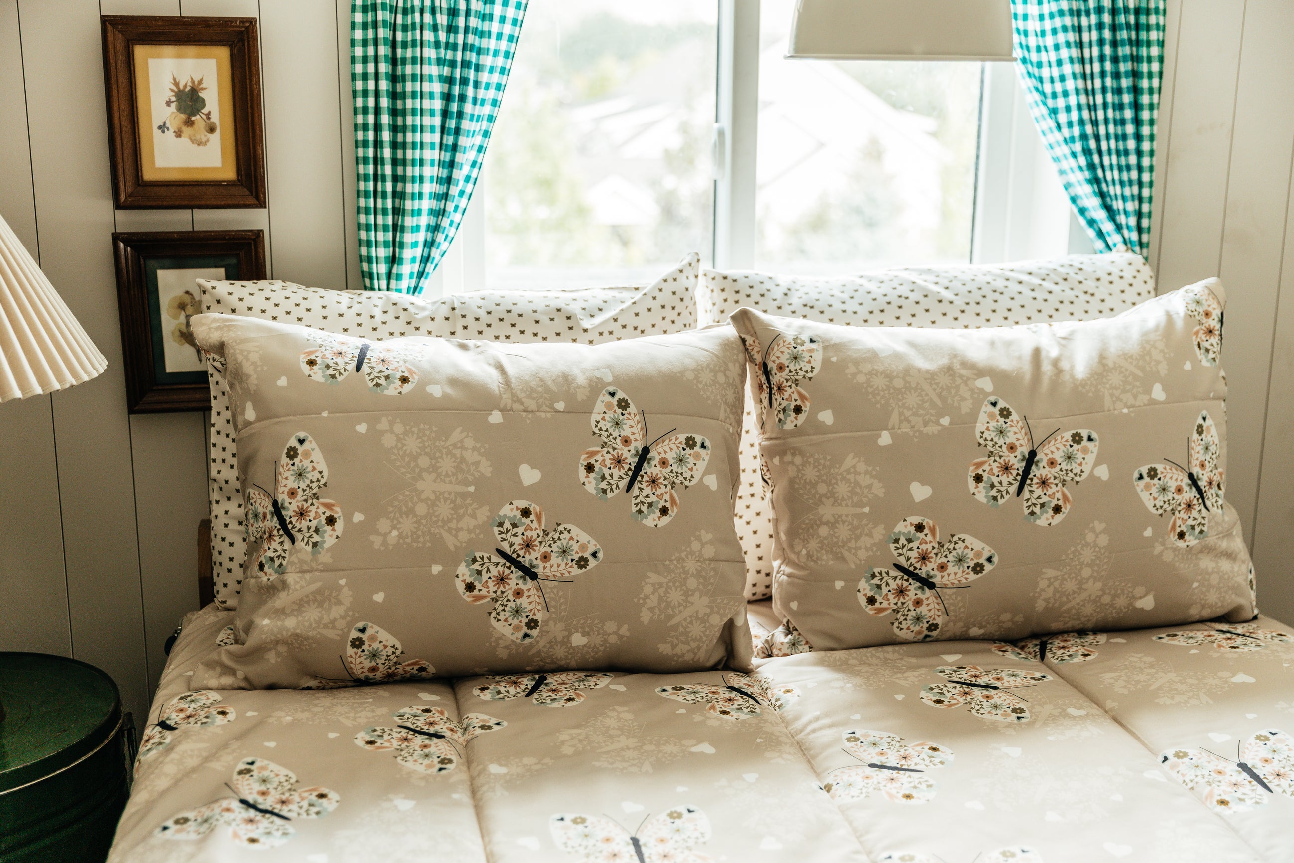 A full size bed made with butterfly zipper bedding, the pillows propped up to showcase the pillowcases and shams.