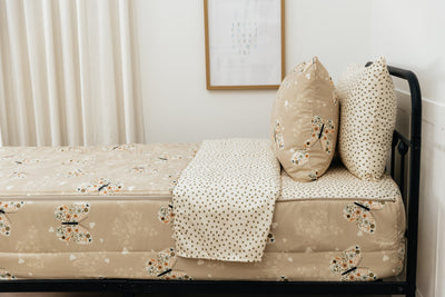 A bed made with butterfly printed zipper bedding, showcasing the pillowcase and sham and the top of the bedding turned down to show the inside lining.