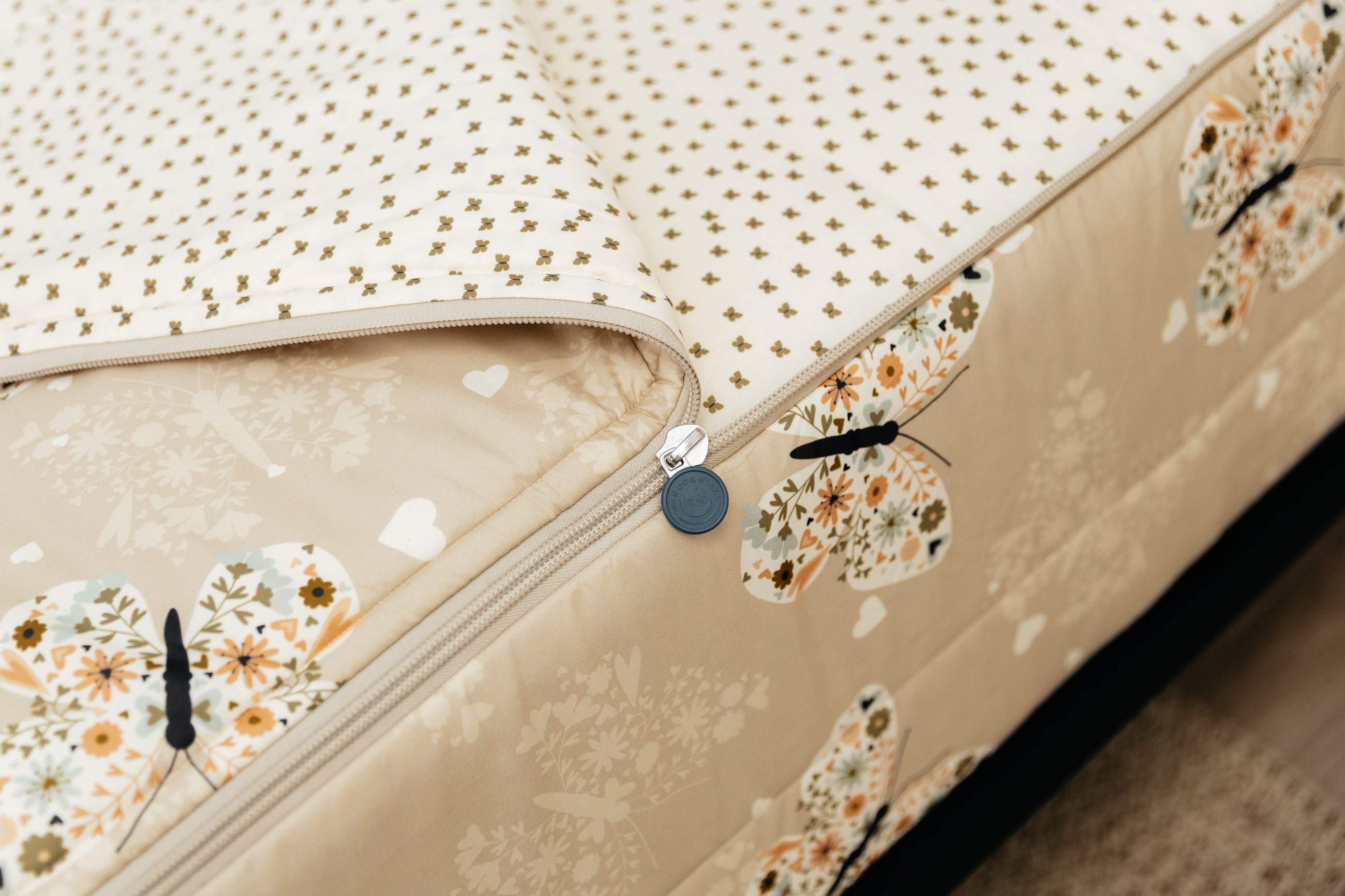 A tight shot of the zipper feature on a set of butterfly printed zipper bedding.