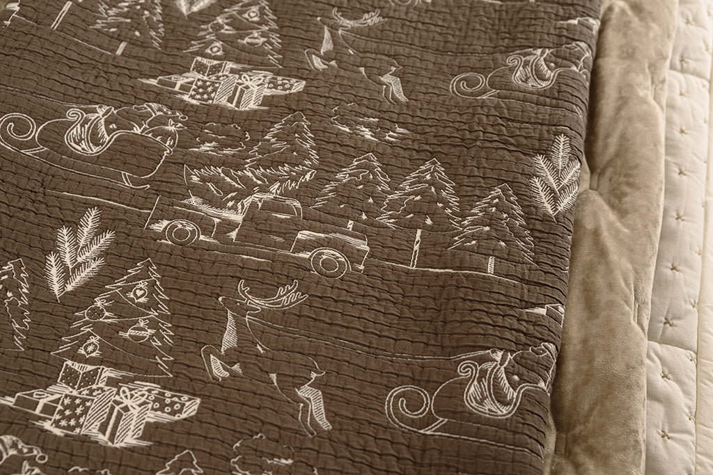 A brown and cream quilted holiday blanket.
