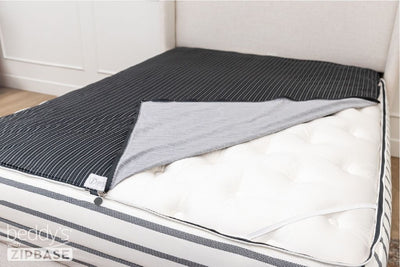 A shot of a zipper bedding set with ZipBase with the inside sheet unzipped and pulled back