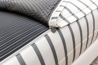 A close up view of the zipper function on white and black striped zipper bedding.