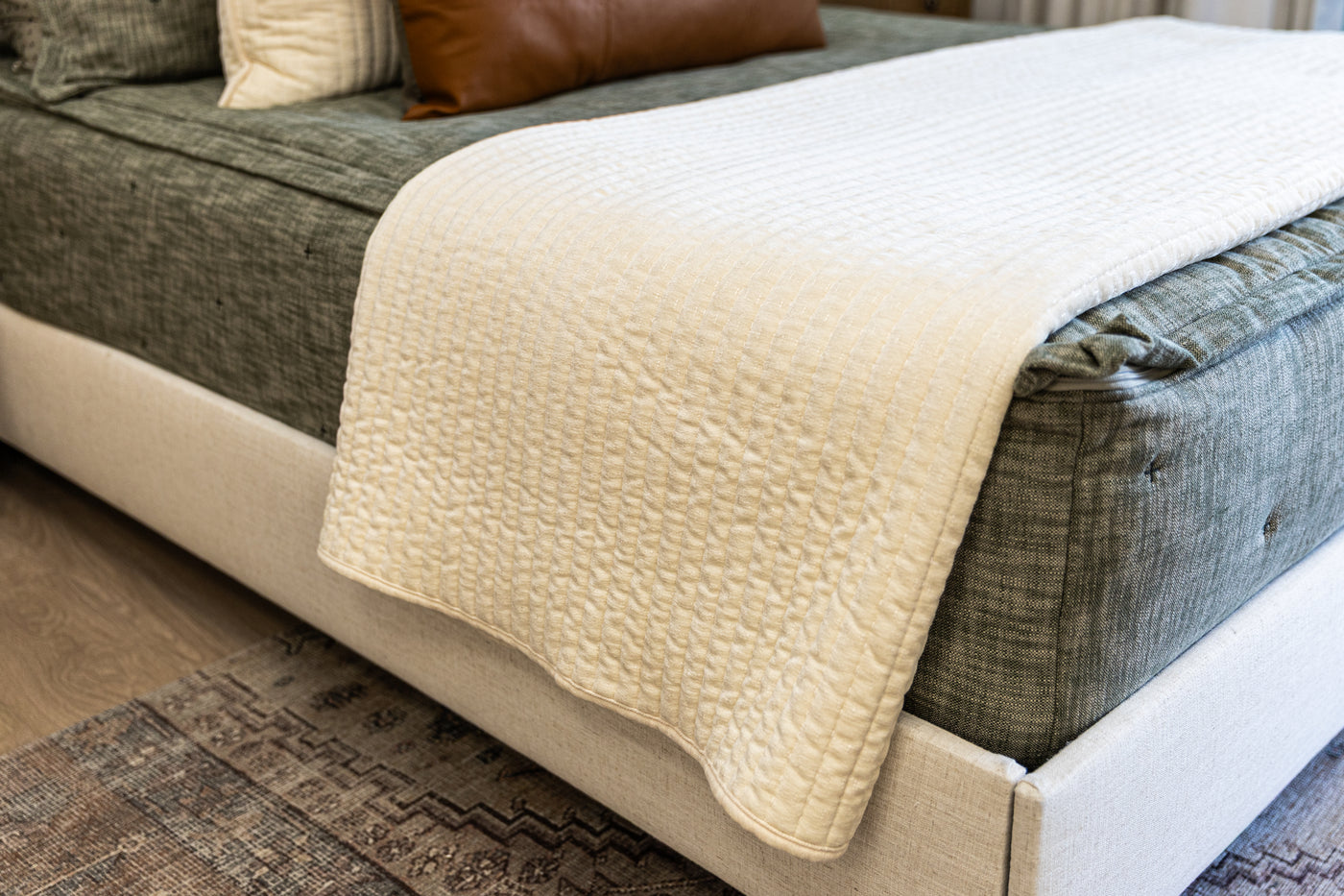 Cream blanket at the end of green zipper bedding