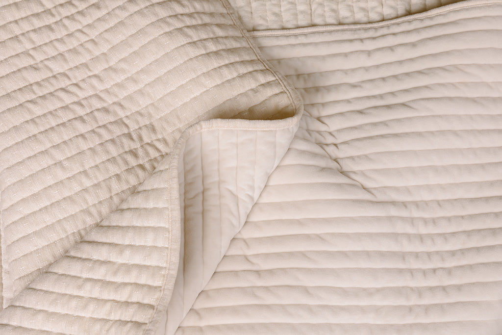 Photo with both textured and minky sides of cream blanket