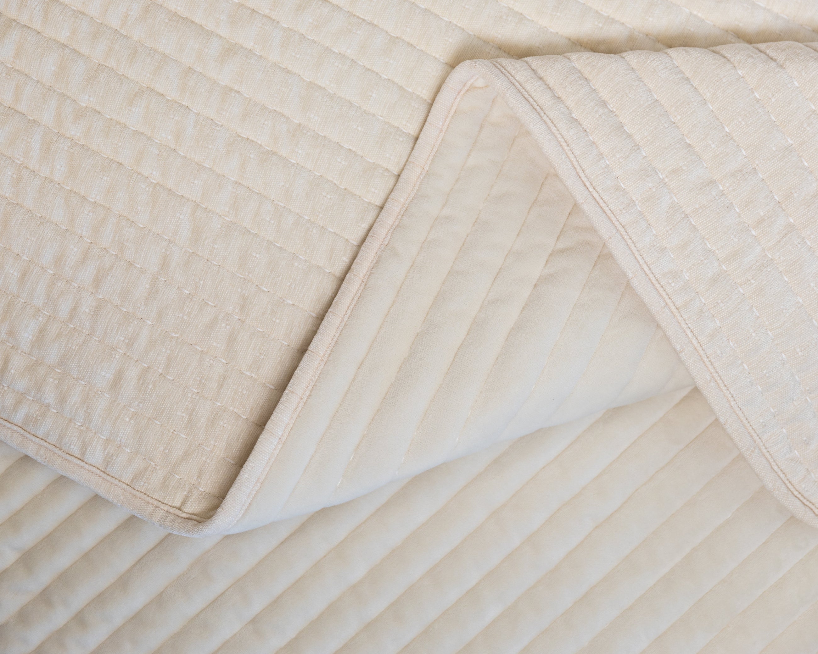 Photo with both textured and minky sides of cream blanket