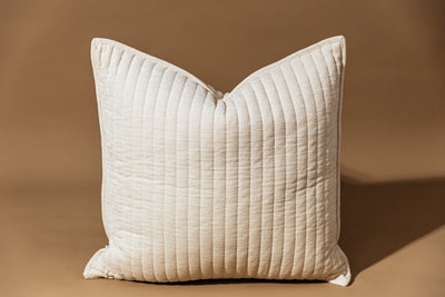 Cream textured pillow on tan background