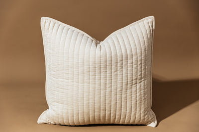 Cream textured pillow on tan background